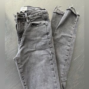Black skinny Frame denim with distressed hem and knee. Size 25.